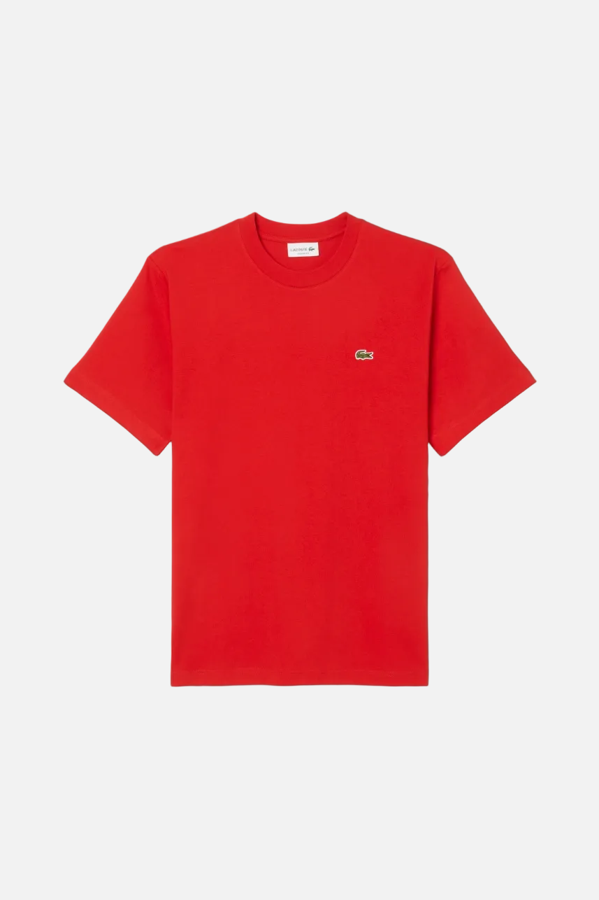 Red t-shirt with a small logo on a light gray background